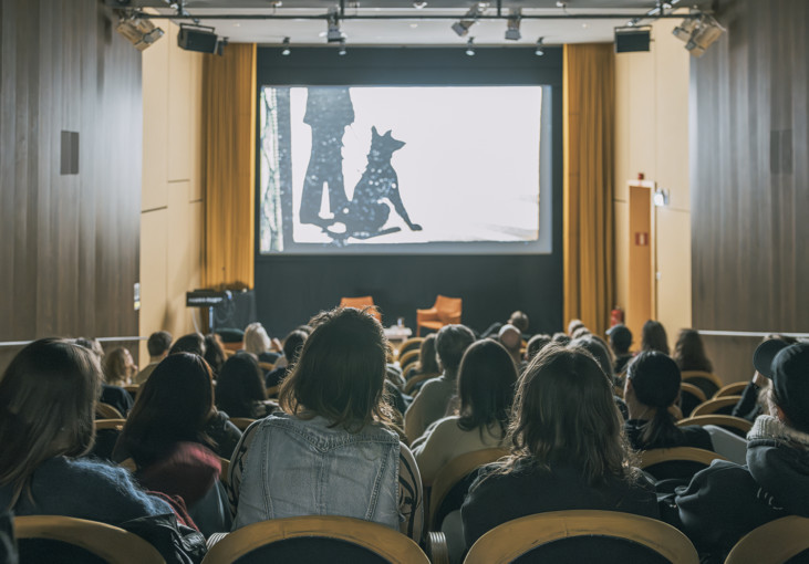 The backs of people sitting in the museum cinema