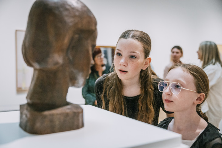 Två barn tittar på en skulptur